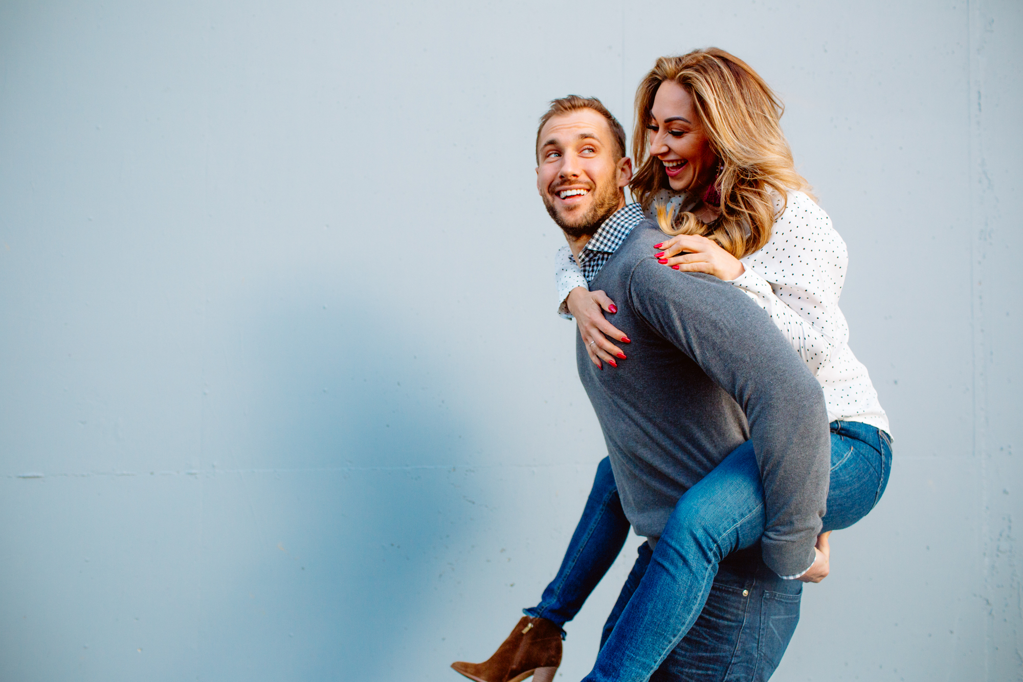 A long dinner table with elegant settings, flowers, and candles, guests seated, some using phones. Beside it, a lit marquee letter "L" glows on a table with candles against a night backdrop. Jessica Hill Photography - Wedding Photographer - Oregon