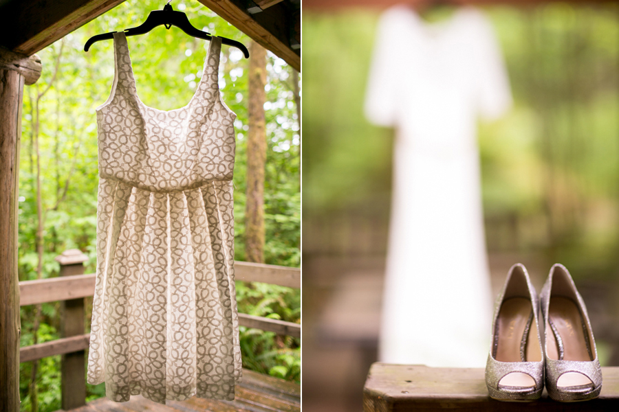 A sleeveless patterned dress hangs on a wooden structure; beside it, an out-of-focus dress and a pair of open-toed heels are displayed on a bench outdoors. Jessica Hill Photography - Wedding Photographer - Oregon