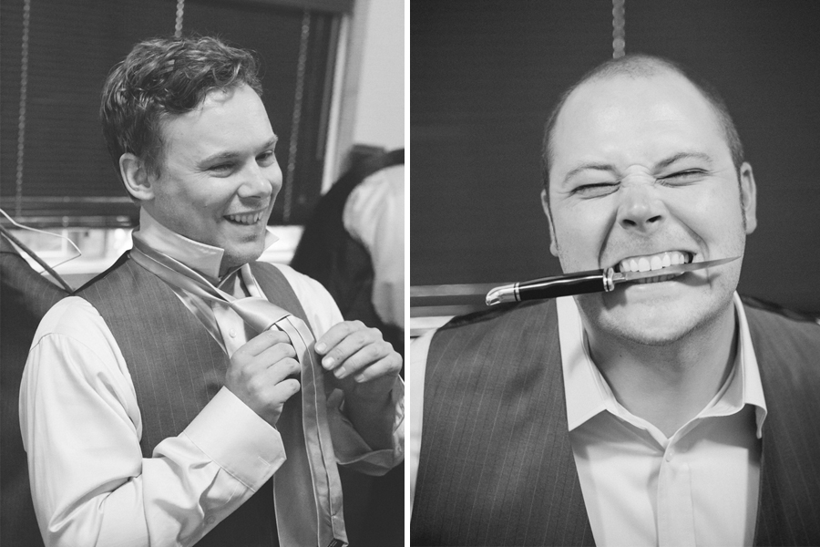 Two men in dress shirts and vests; one adjusts his tie and smiles, the other grins while holding a knife horizontally between his teeth. Jessica Hill Photography - Wedding Photographer - Oregon