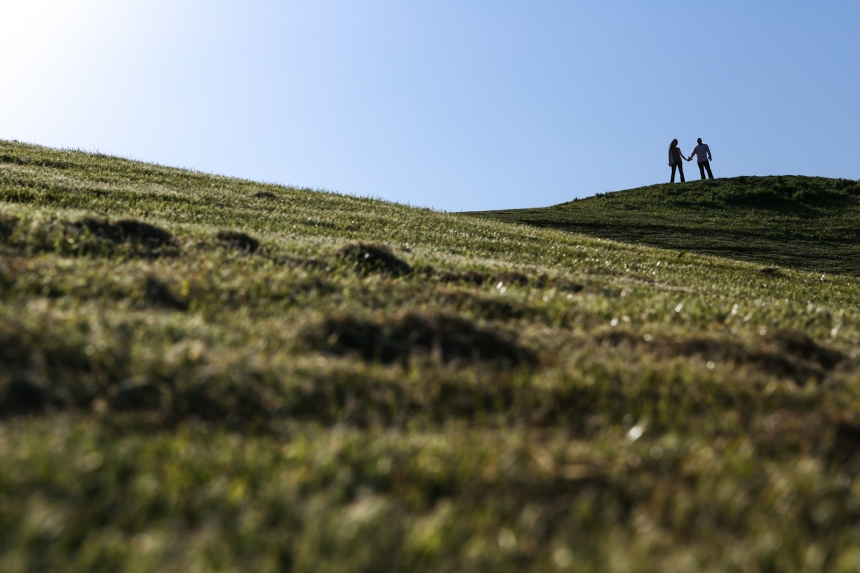 Best_Of_2012_010 (1) Two people hold hands while standing on a grassy hill under a clear blue sky. Jessica Hill Photography - Wedding Photographer - Oregon