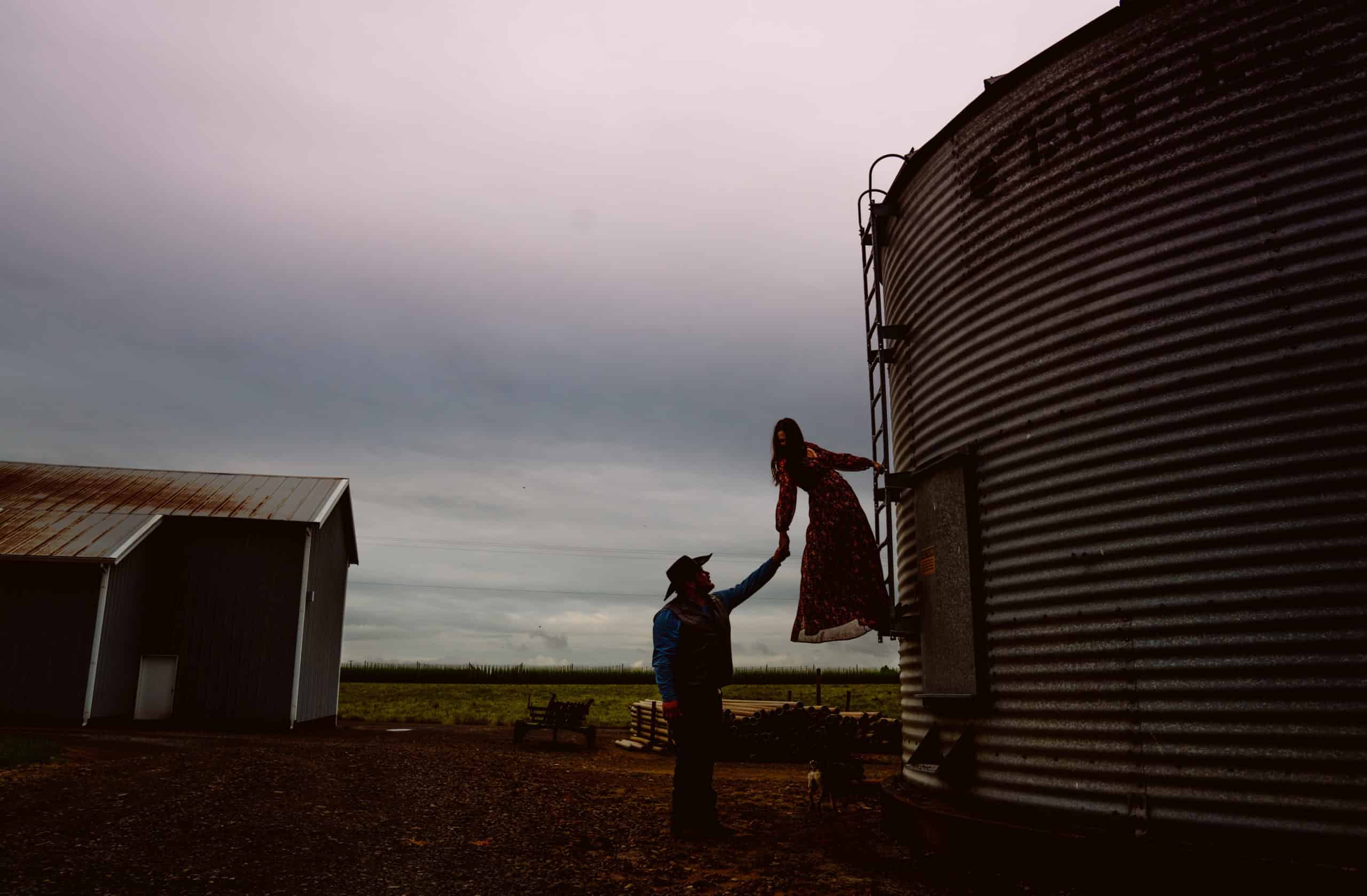 Person helping woman climb silo ladder