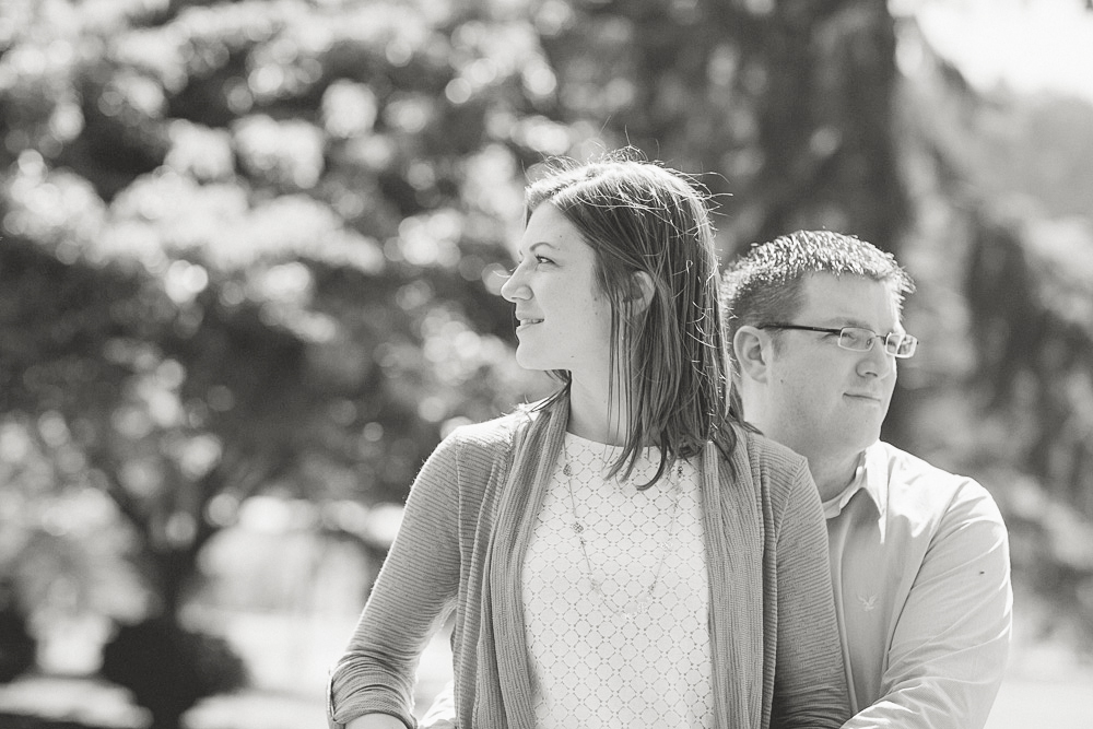 A woman and a man stand close together outdoors, both looking in opposite directions. The image is in black and white. Jessica Hill Photography - Wedding Photographer - Oregon