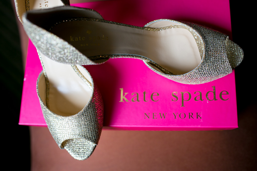 A pair of sparkly, silver open-toe heels rests on a bright pink Kate Spade New York shoebox. Jessica Hill Photography - Wedding Photographer - Oregon