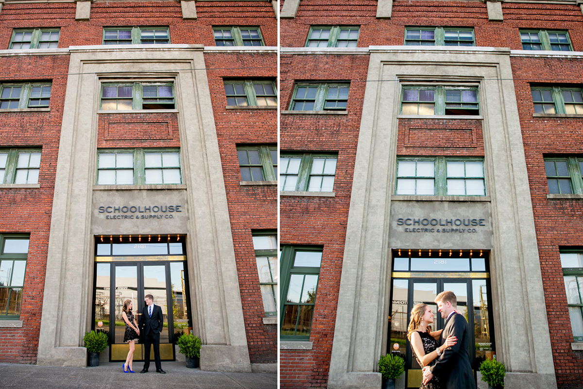 A man and woman stand and embrace outside the entrance of a red brick building labeled "Schoolhouse Electric & Supply Co. Jessica Hill Photography - Wedding Photographer - Oregon