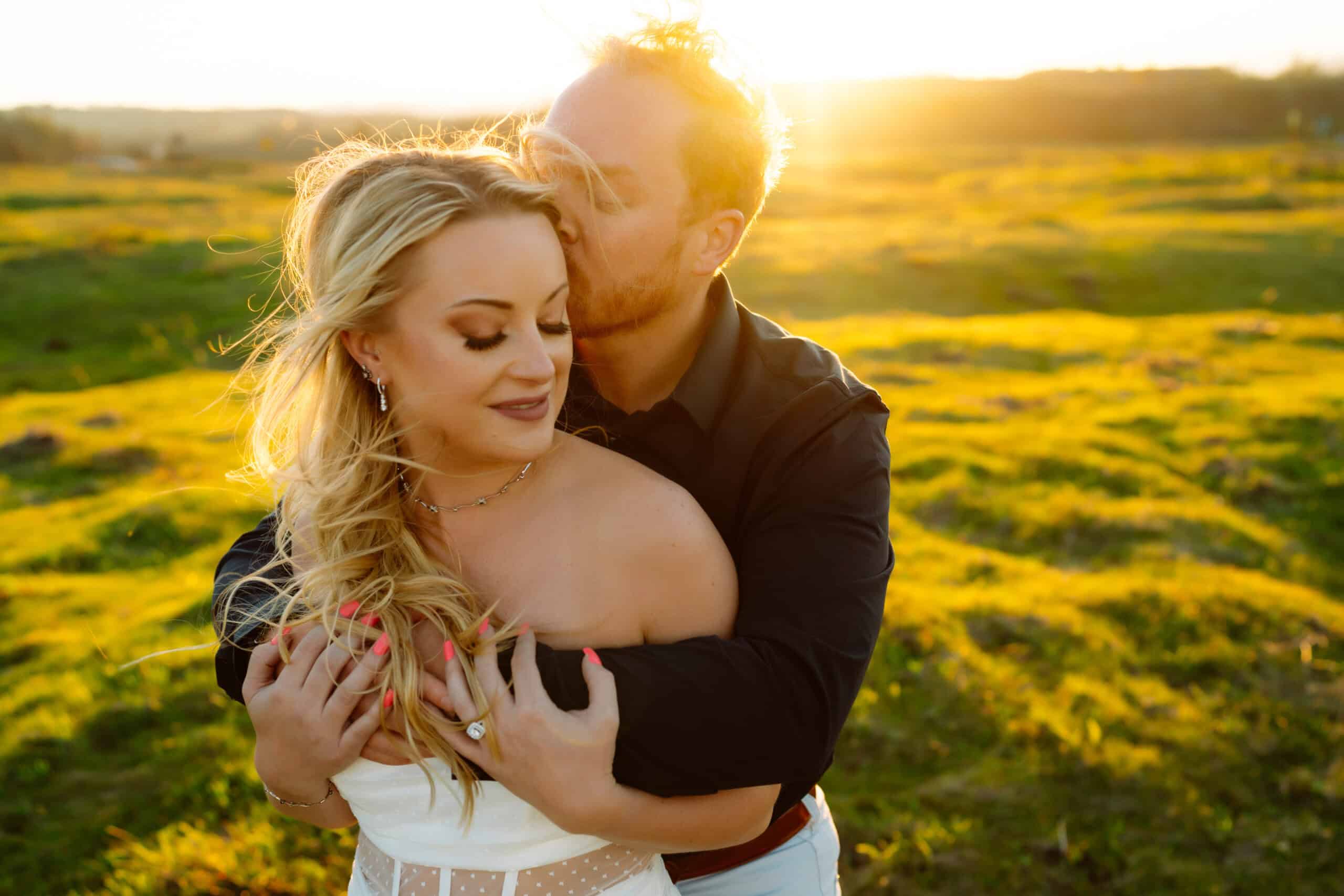 Couple embracing in sunny field