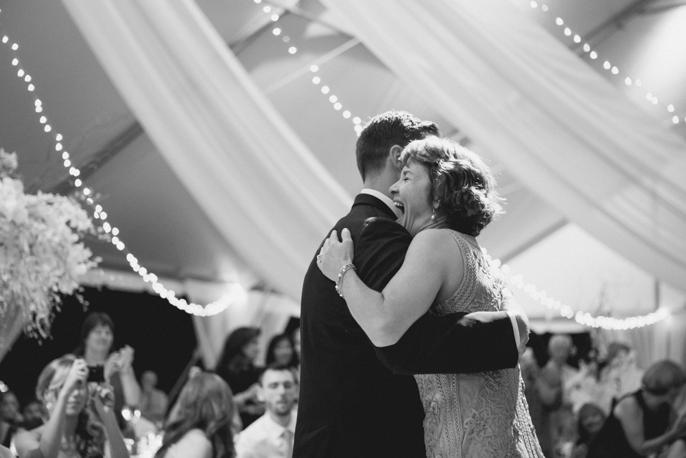 A bride in a white strapless dress and a groom in a dark suit hold Scrabble tiles spelling "ALICE AND SCOTT" in wooden racks, standing side by side outdoors. Jessica Hill Photography - Photographer - Oregon