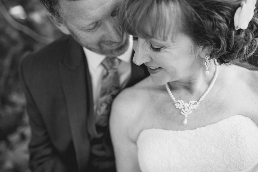 A bride and groom sit close together, smiling and looking at each other. The image is in black and white. Jessica Hill Photography - Wedding Photographer - Oregon
