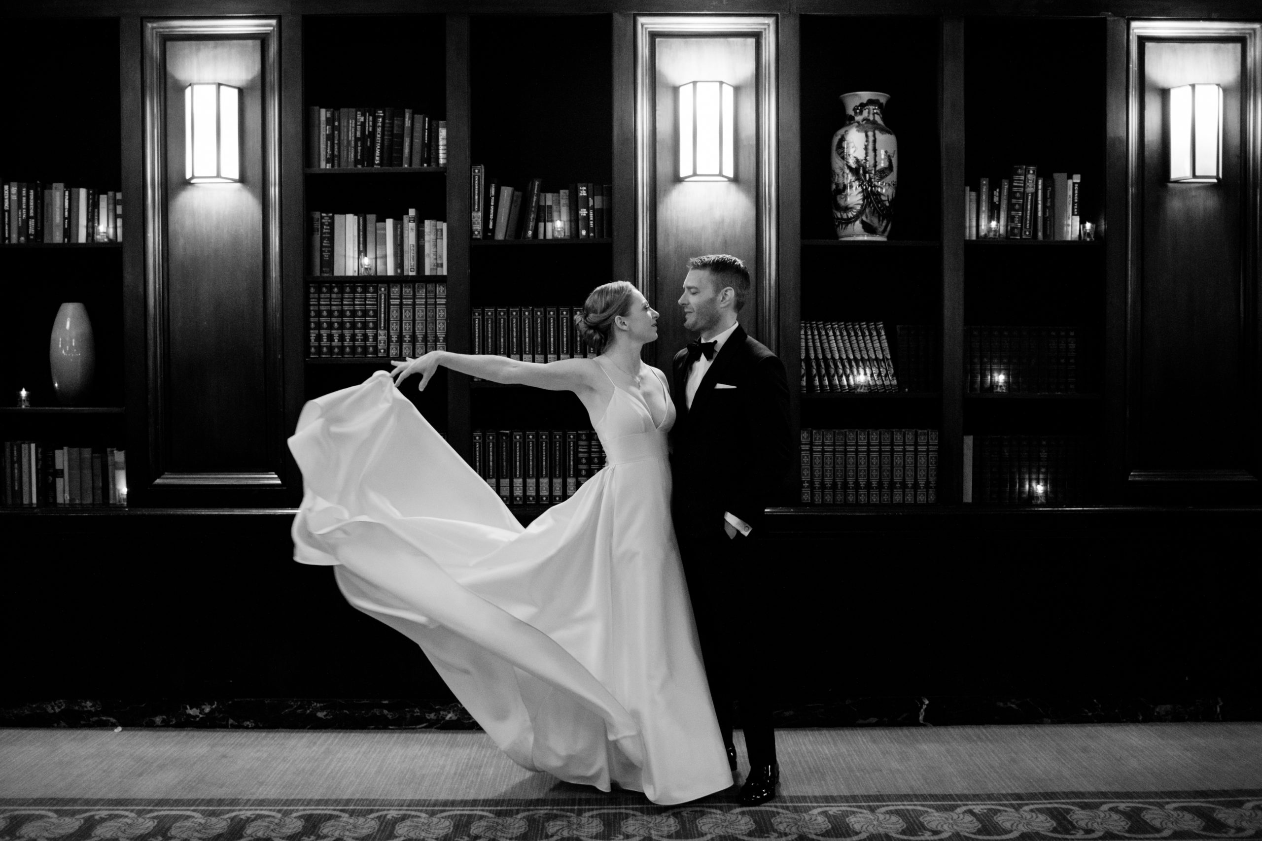 Couple dancing in elegant library setting.