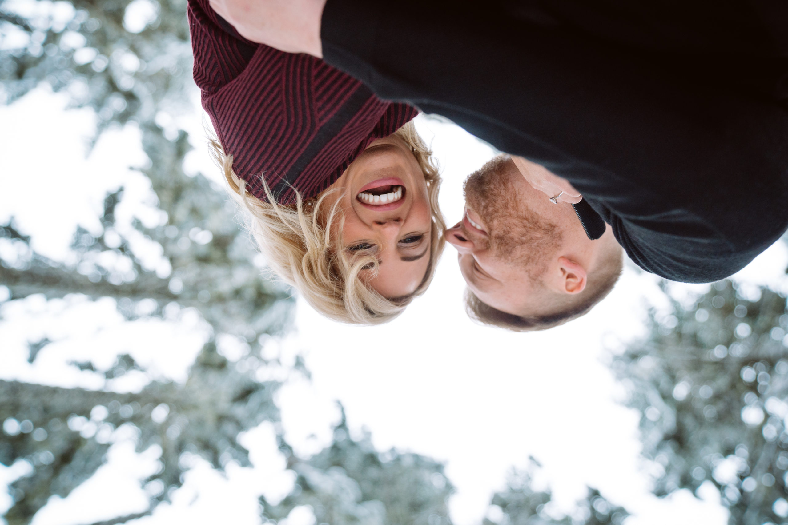 Couple smiling upside down in snowy forest