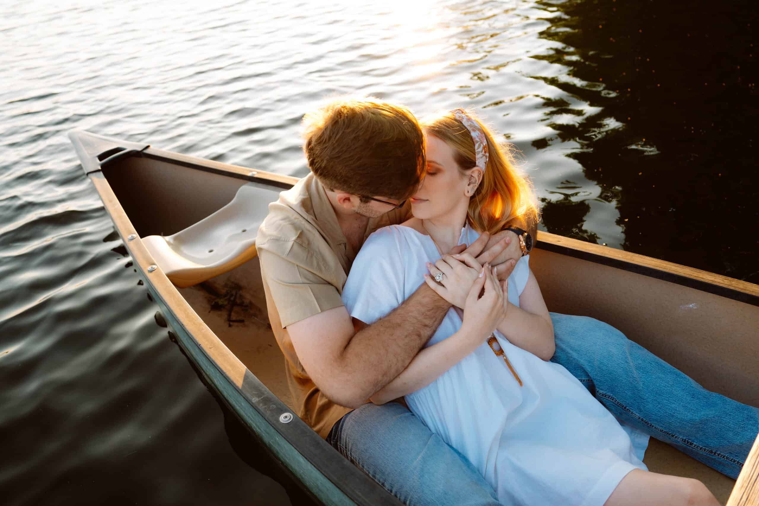 Couple embracing on a boat during sunset.