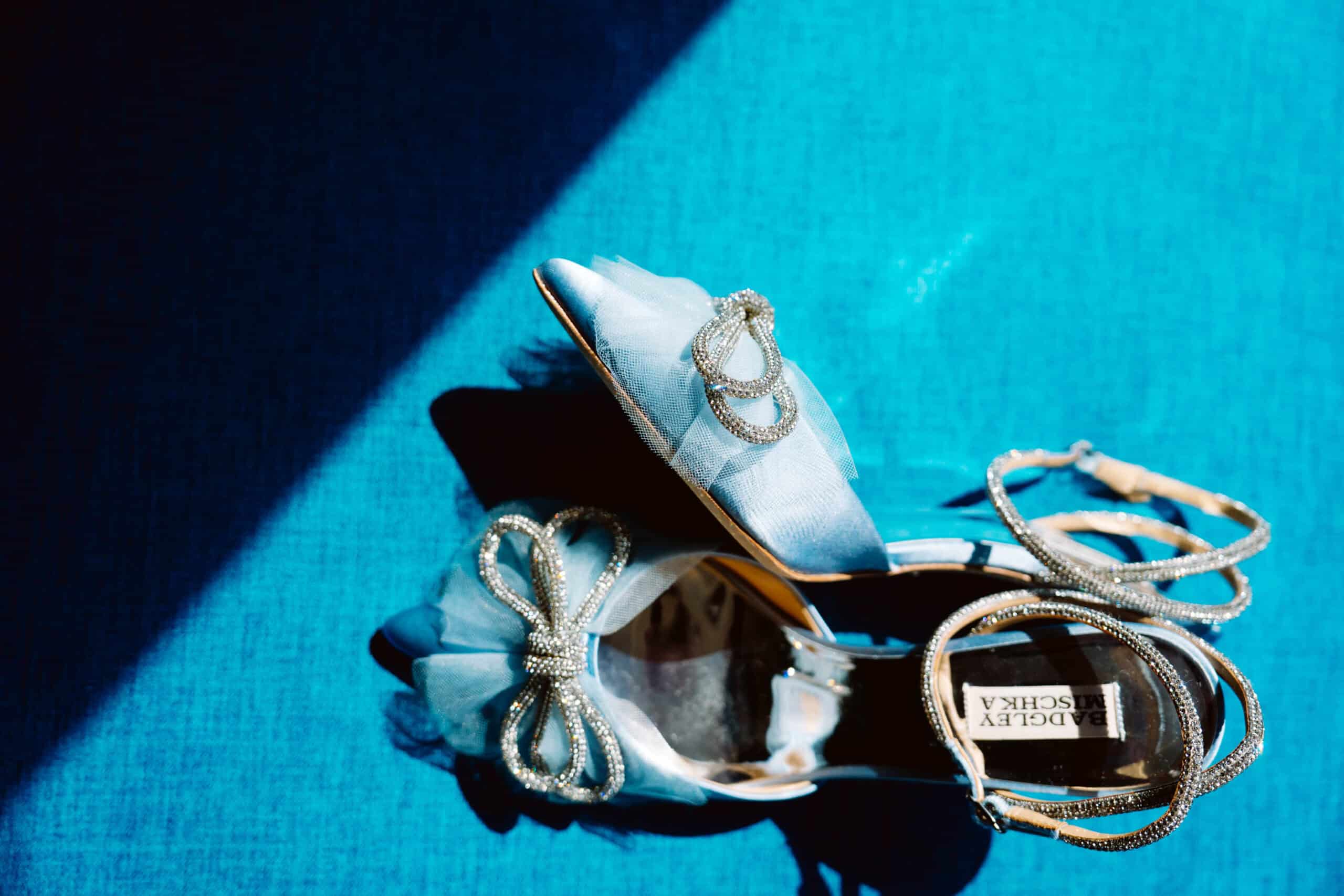 Elegant blue shoes with decorative bows and pearls.