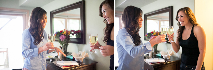 Two women standing indoors smile and toast with glasses of white wine near a dresser with flowers and papers on it. Jessica Hill Photography - Wedding Photographer - Oregon