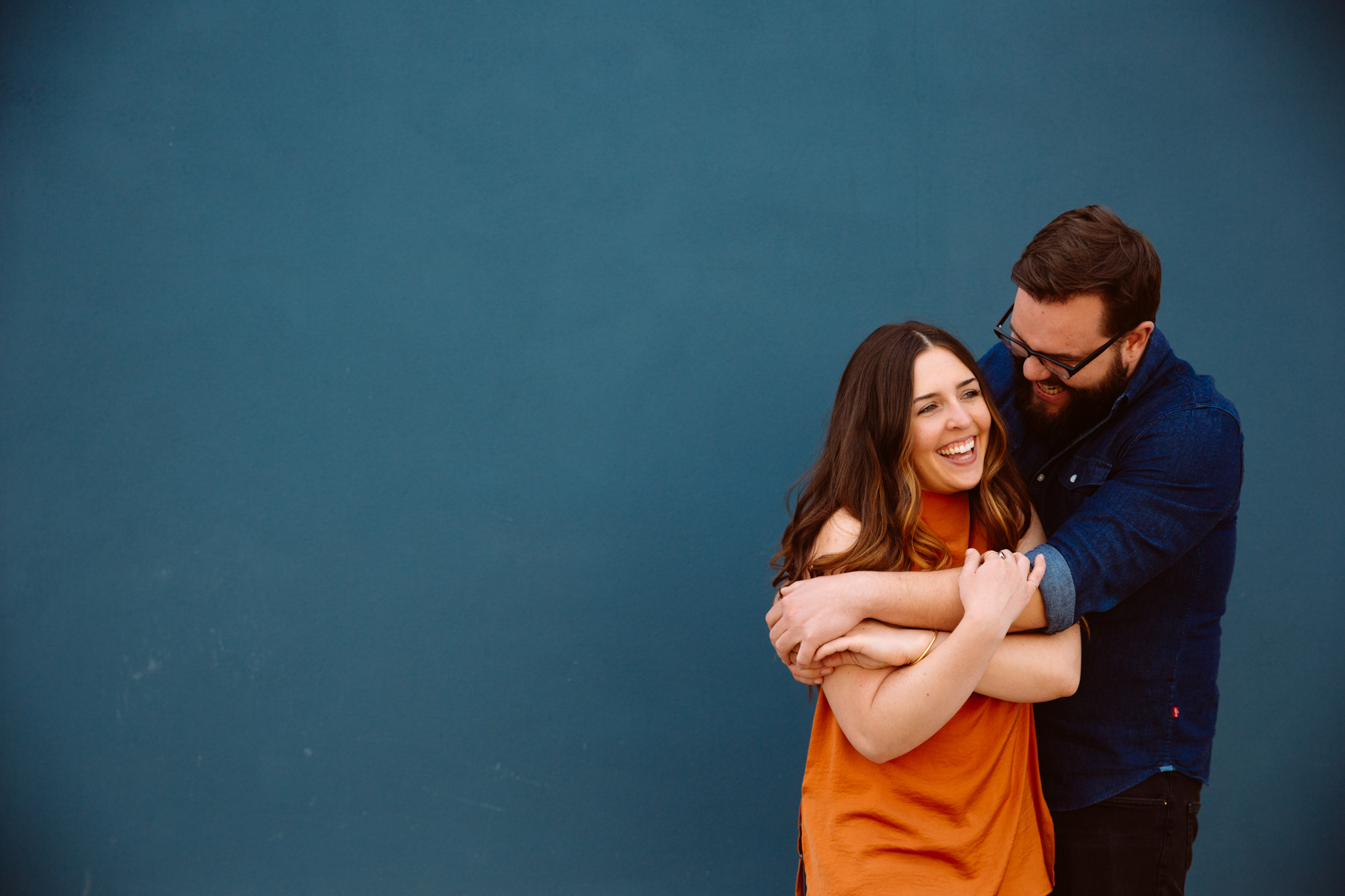 A pair of sparkly high-heeled shoes sit on top of a light gray tufted couch, with two black-and-white framed photos hanging on a dark gray wall above. Jessica Hill Photography - Wedding Photographer - Oregon