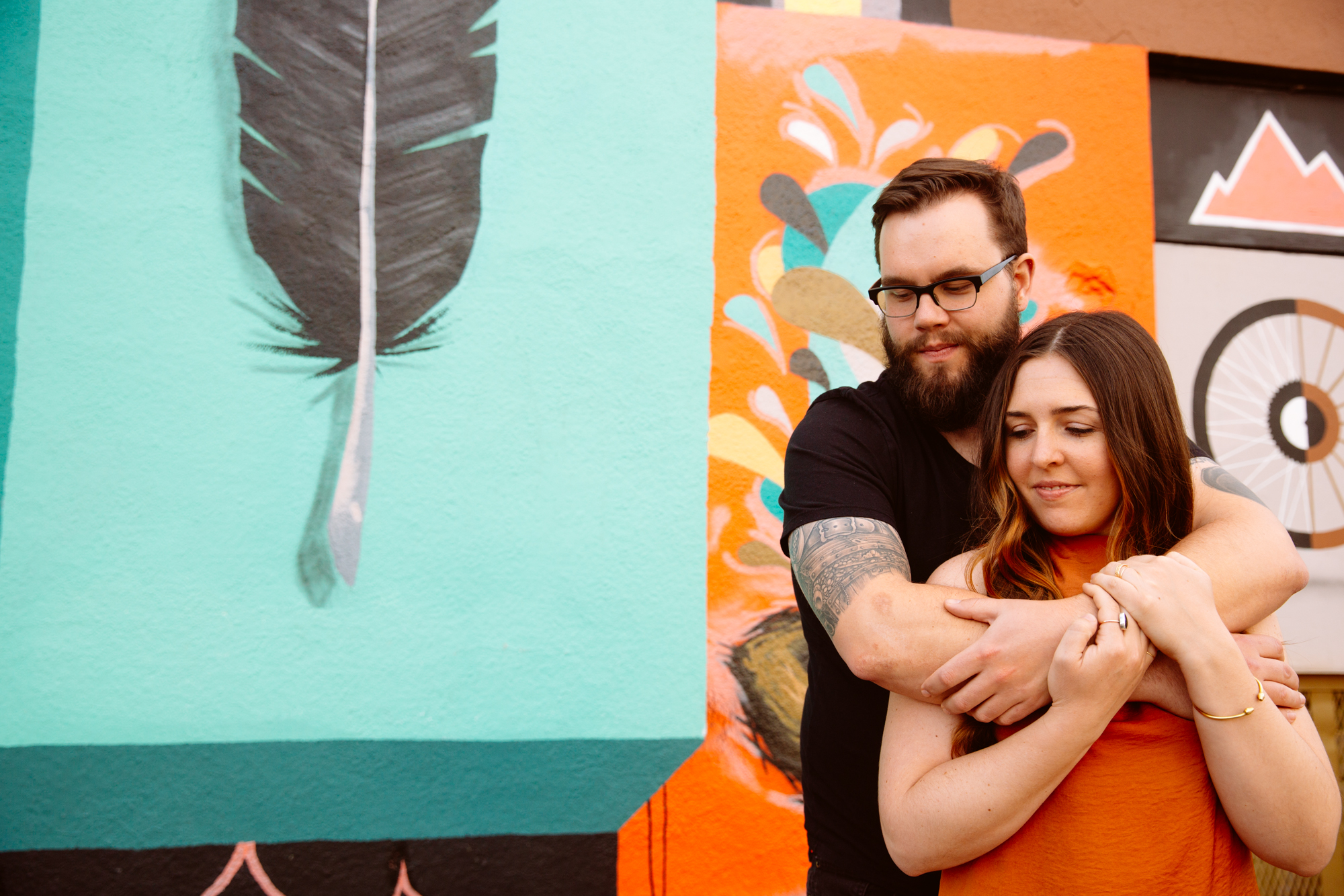A couple dressed formally shares a kiss while seated at an outdoor evening event, surrounded by soft string lights and greenery. Other guests are visible in the background. Jessica Hill Photography - Wedding Photographer - Oregon