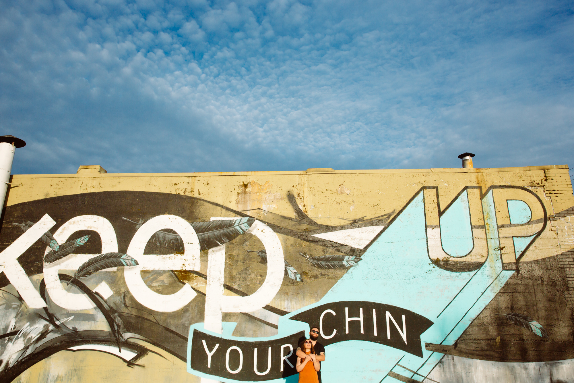 A bride and groom smile as they cut their wedding cake together. The bride holds the knife while the groom stands close, guiding her hand. The image is in black and white. Jessica Hill Photography - Wedding Photographer - Oregon