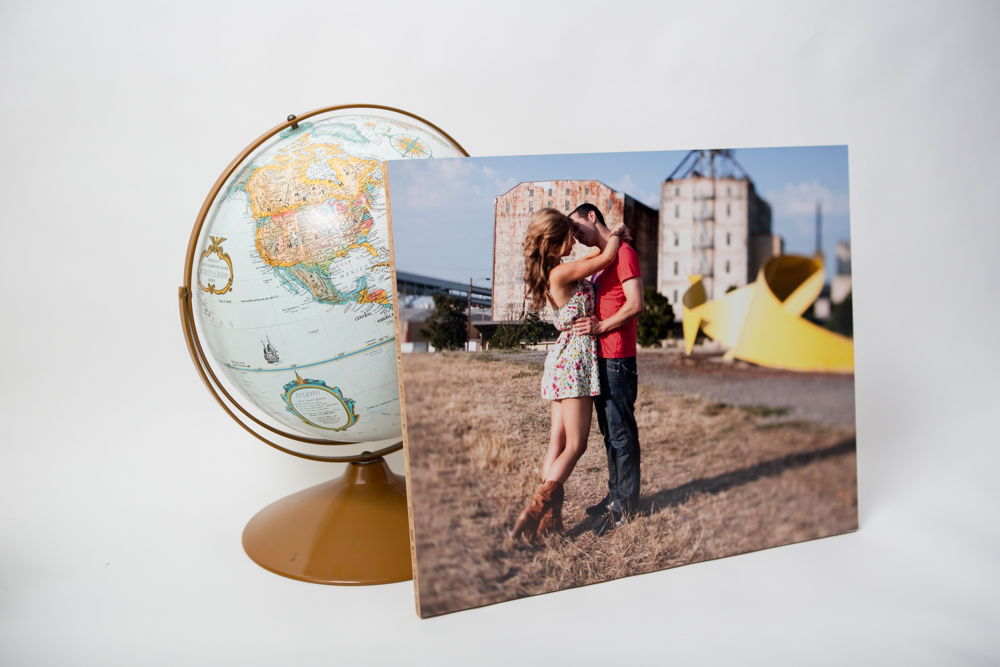 A globe and a photo print of a couple embracing outdoors are arranged side by side against a plain white background. Jessica Hill Photography - Wedding Photographer - Oregon
