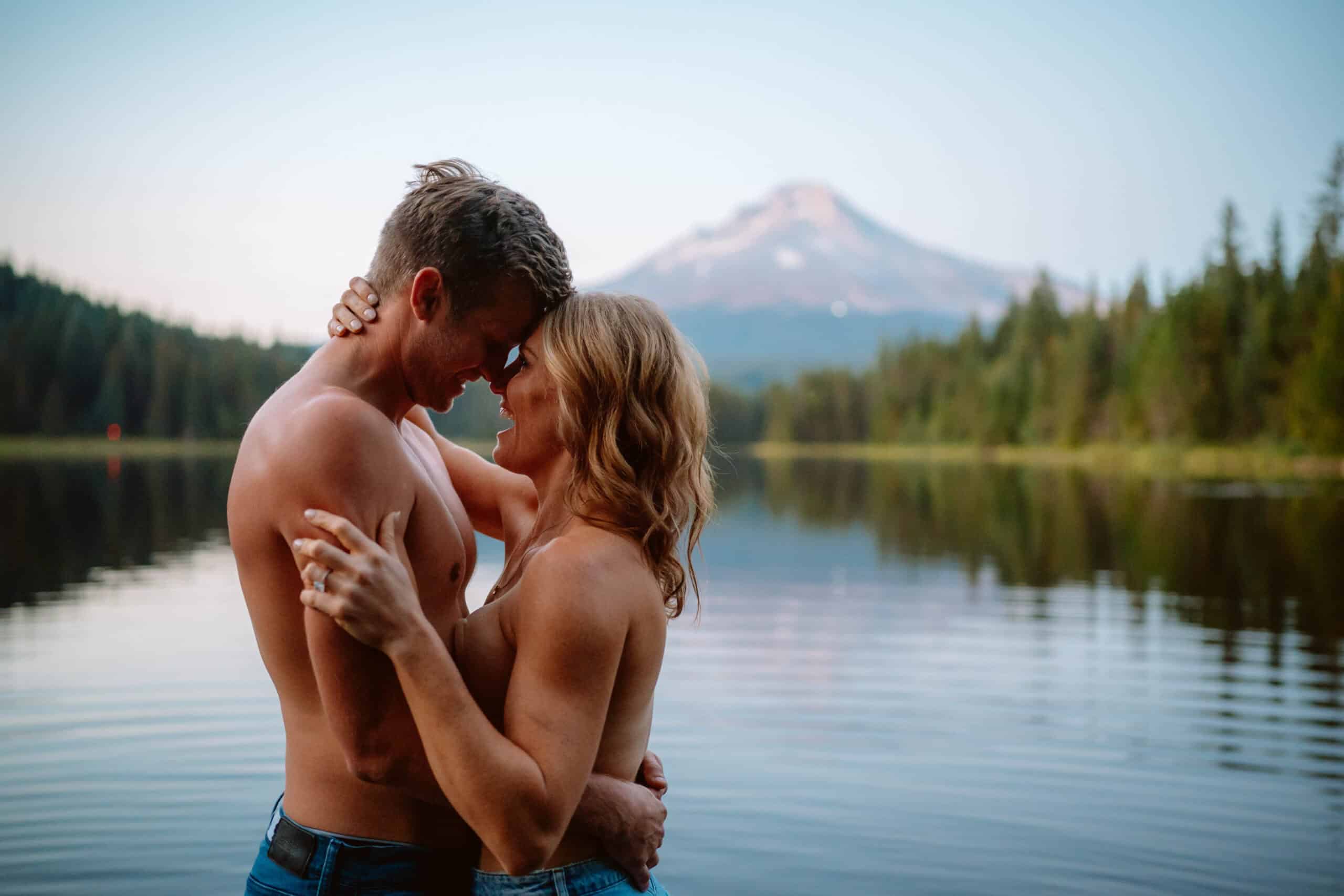 Couple embracing by a scenic mountain lake.