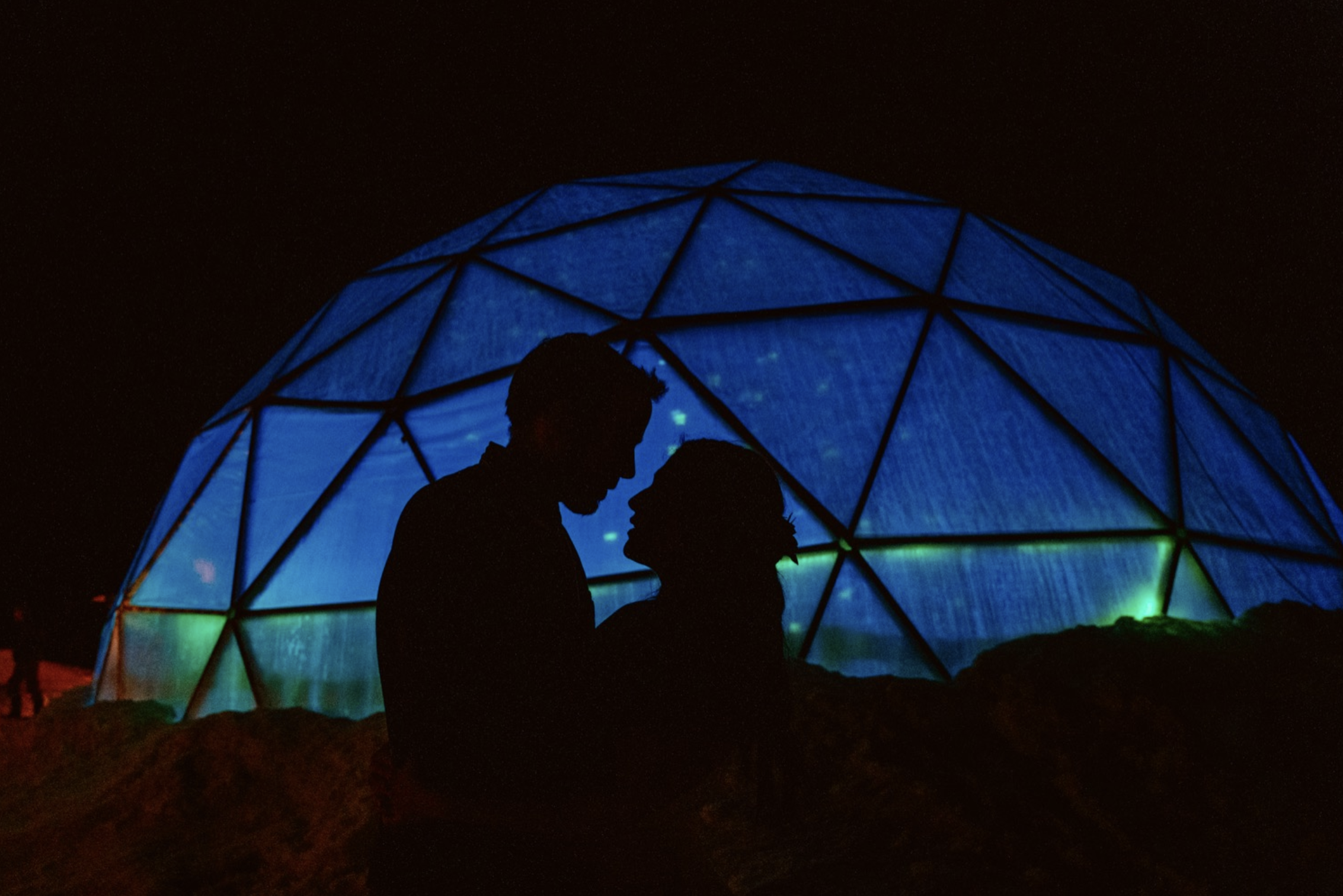 Silhouette of couple near illuminated geodesic dome