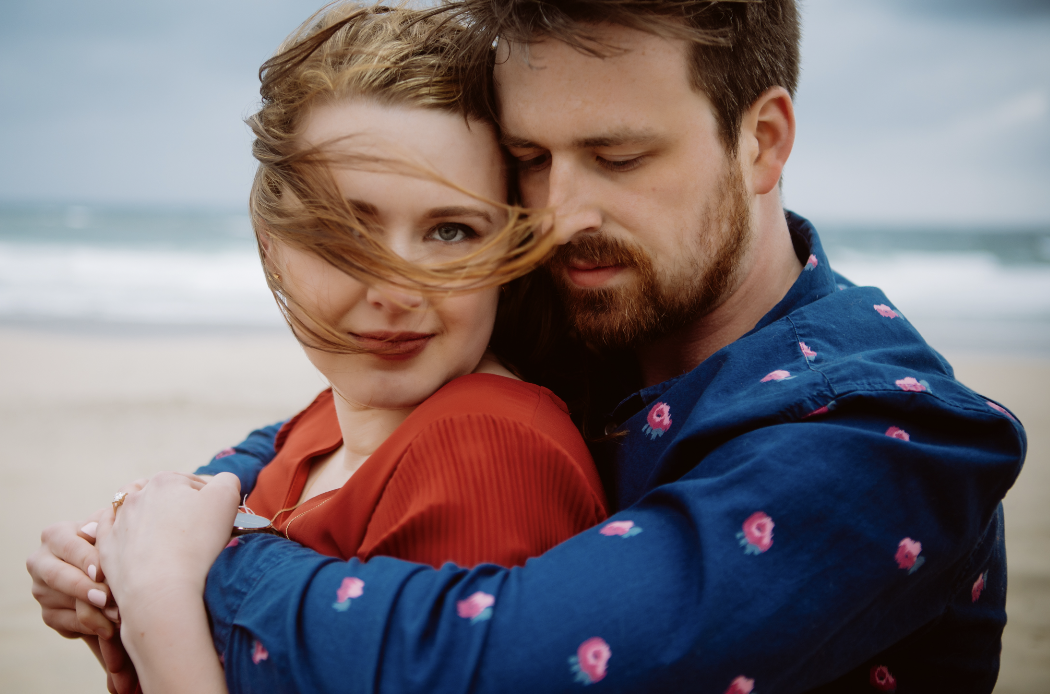 Couple embracing on windy beach