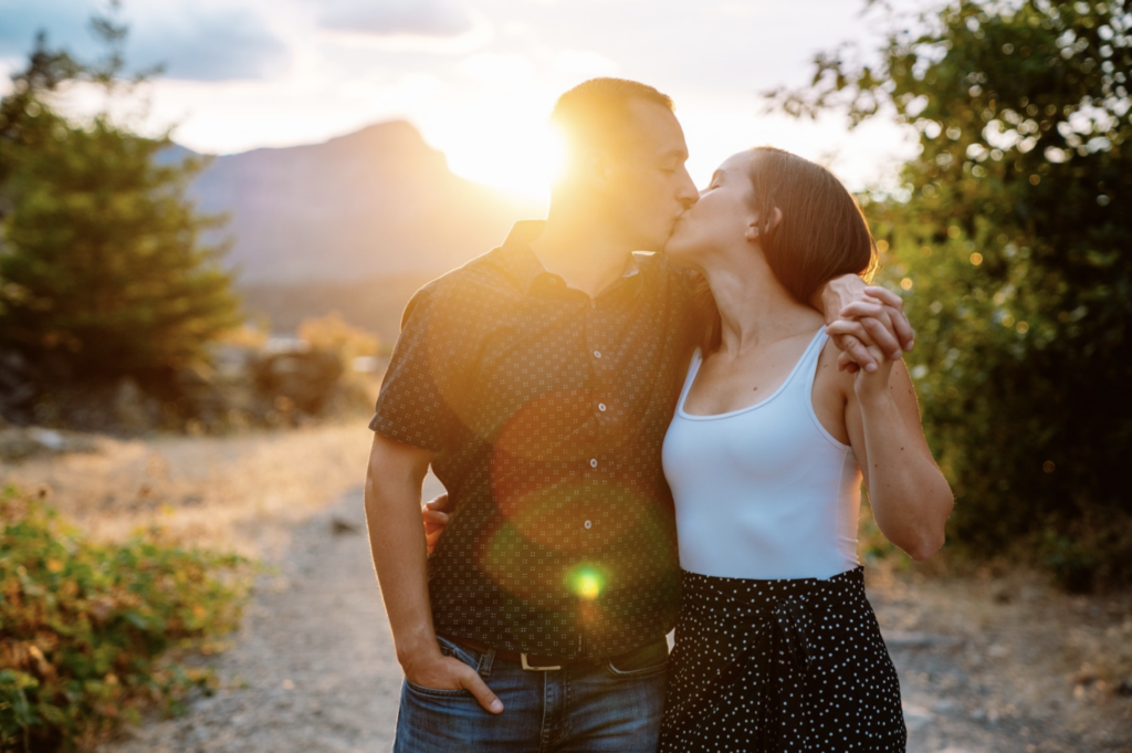 Couple kissing at sunset in nature.