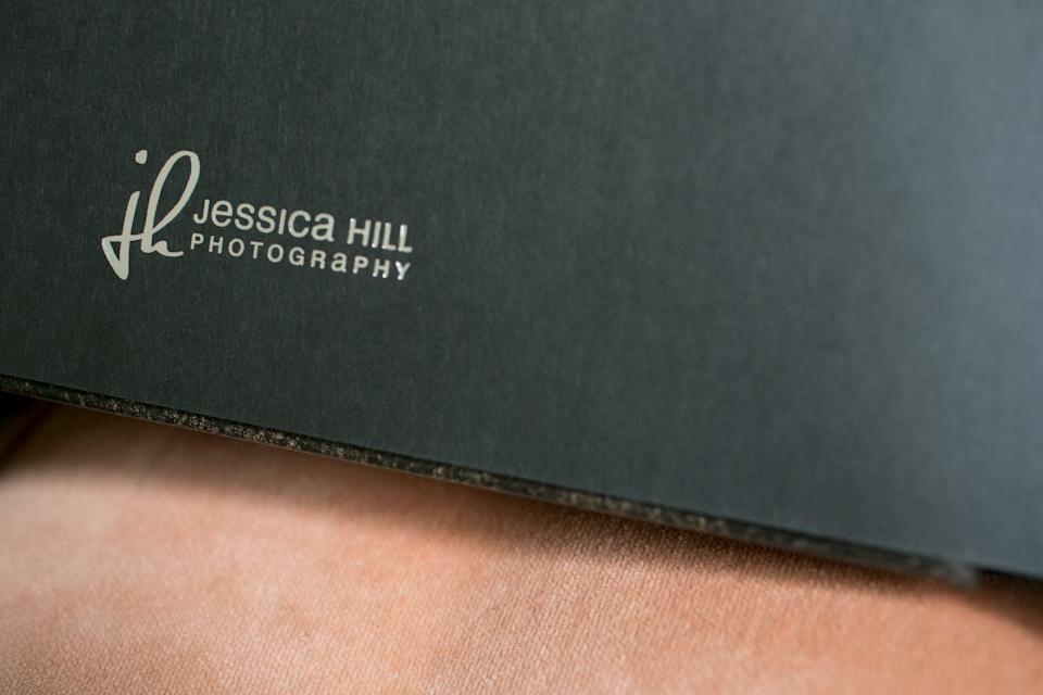 Close-up of a black folder or photo album with the logo and text "Jessica Hill Photography" visible on the cover. Jessica Hill Photography - Wedding Photographer - Oregon