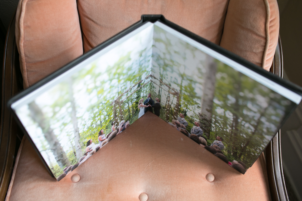 Open photo album with images of people outdoors, placed on a peach-colored cushioned chair. Jessica Hill Photography - Wedding Photographer - Oregon