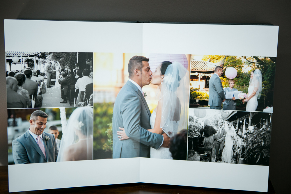 An open wedding photo album displays several pictures of a couple's outdoor ceremony, including their first kiss and exchanging vows. Jessica Hill Photography - Wedding Photographer - Oregon