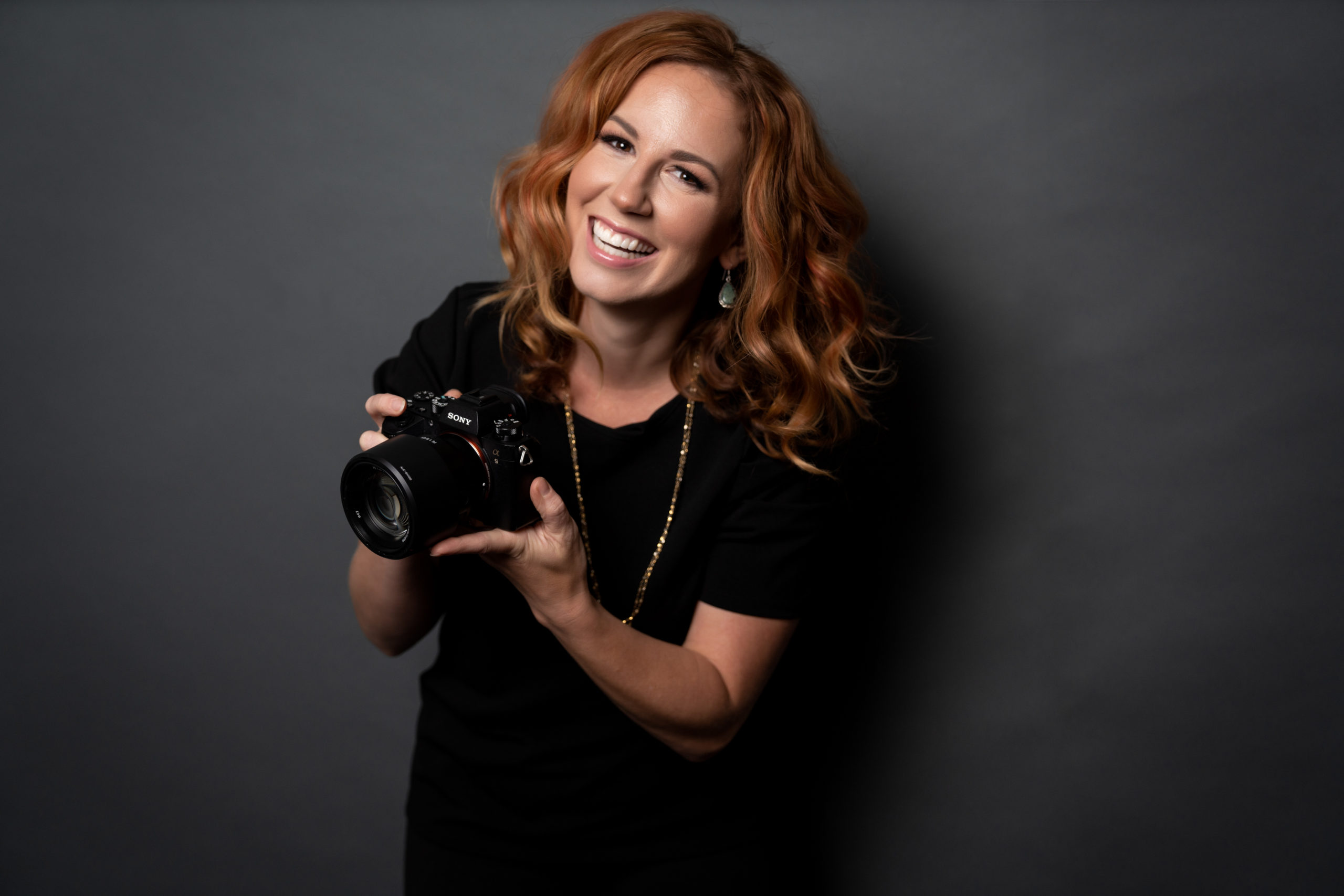 Smiling person holding a camera
