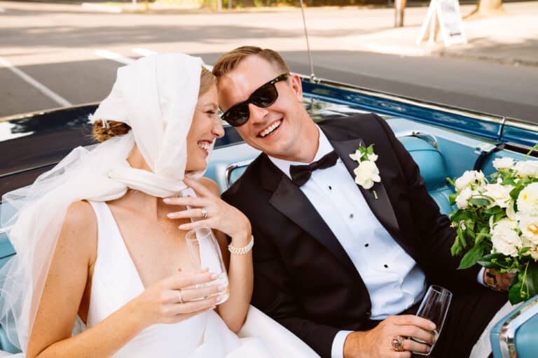 Smiling bride and groom in vintage car