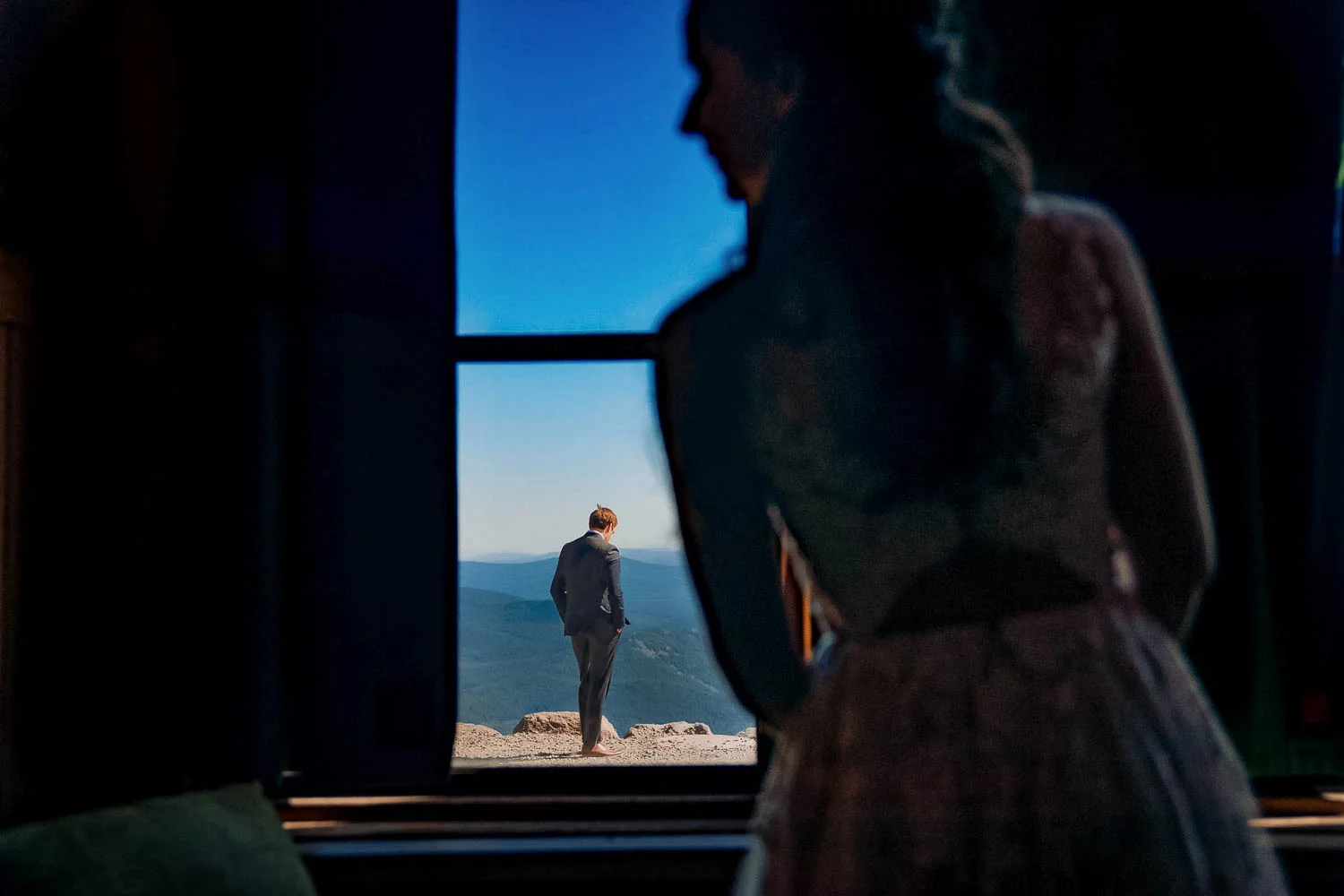 Silhouetted couple in doorway with scenic mountain view.