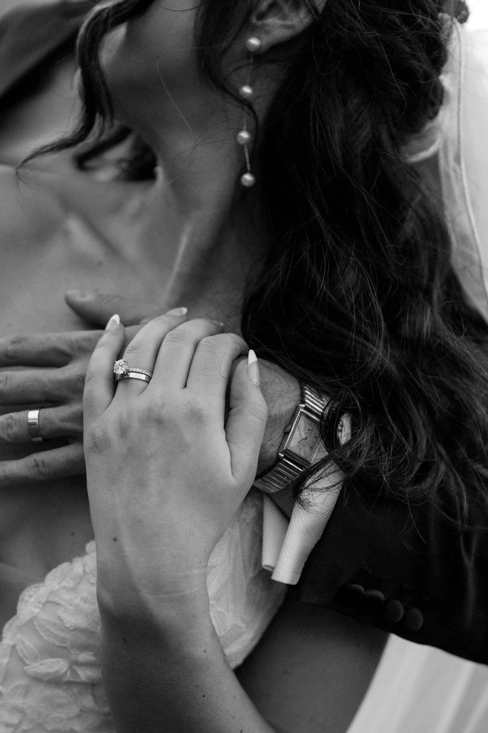 Close-up of wedding couple embracing, rings visible