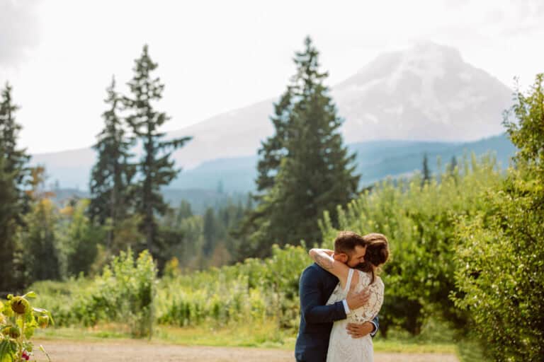 Couple embraces in scenic mountain landscape.