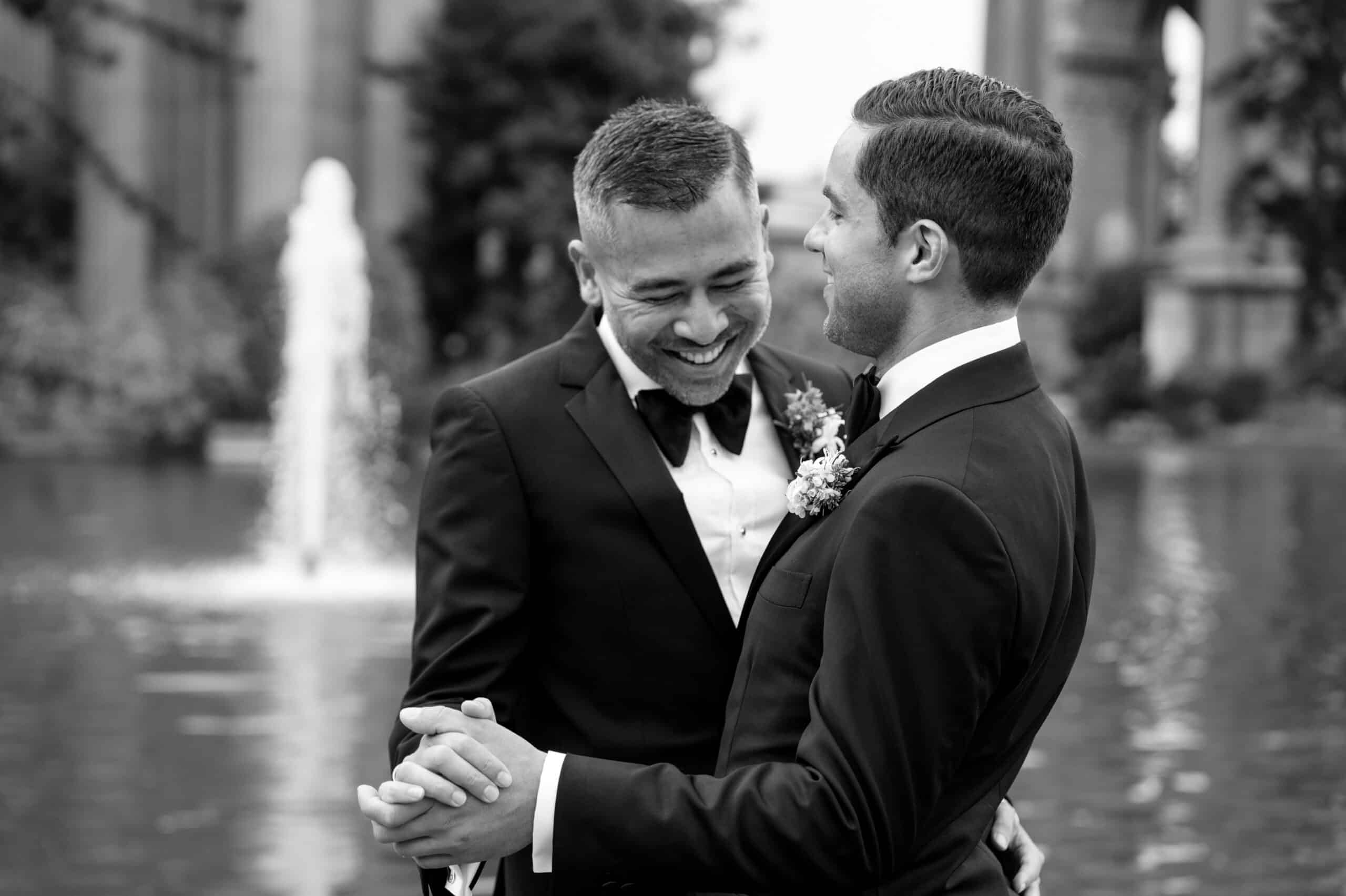 Happy couple dancing by a fountain.