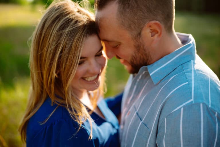 Smiling couple embracing in sunny field